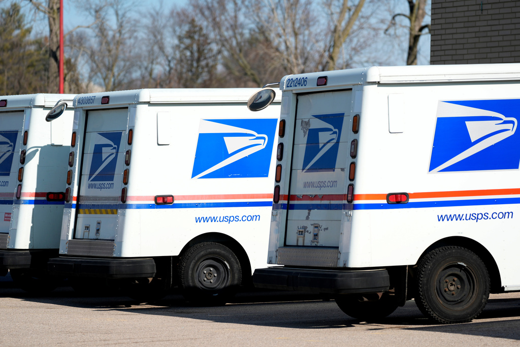 U.S. Postal Service trucks park outside a post office.