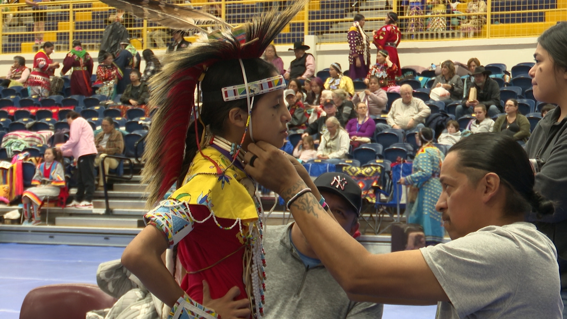 Man adjusting a child's headdress
