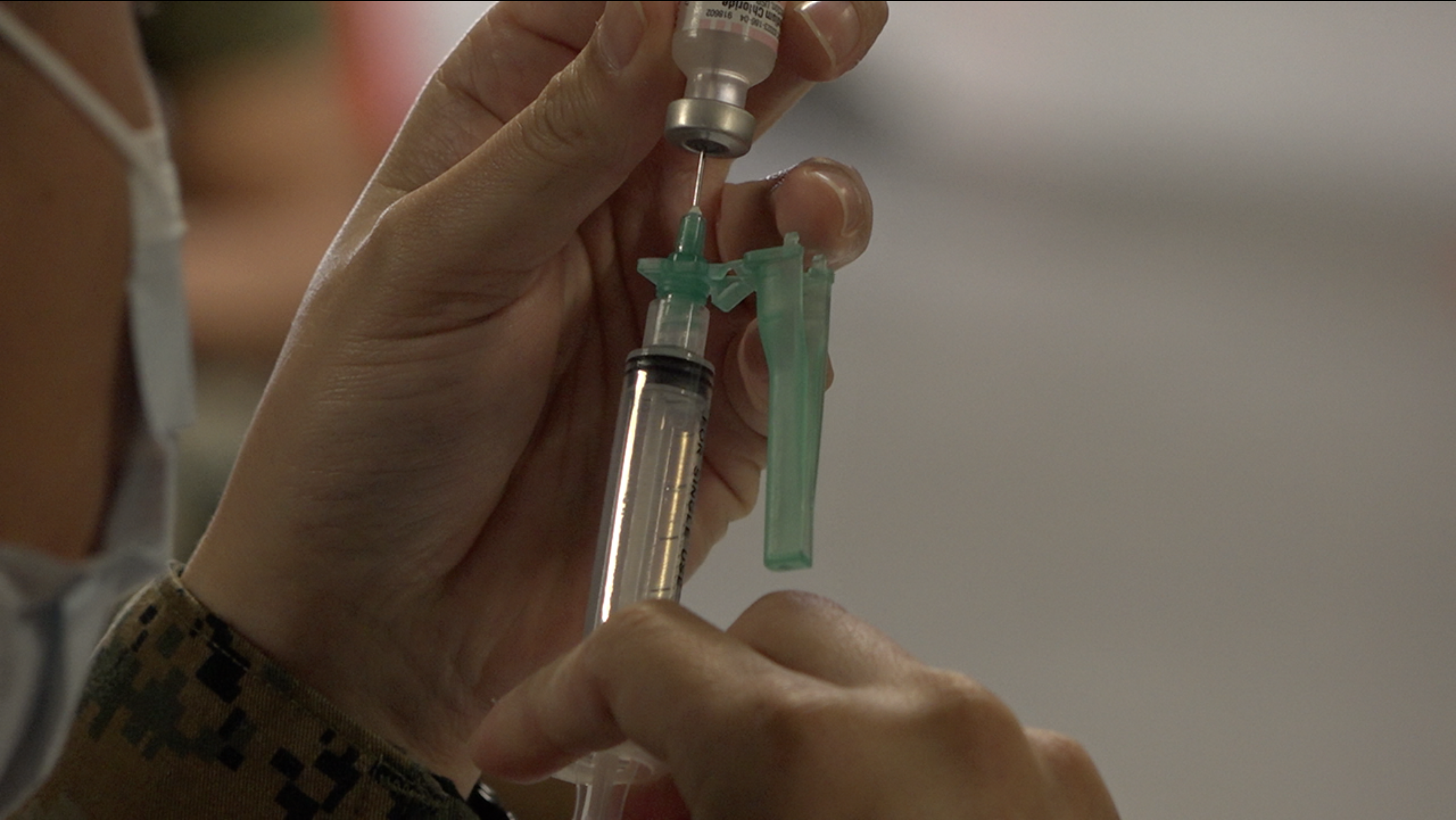 Marine prepares syringe with COVID-19 vaccine