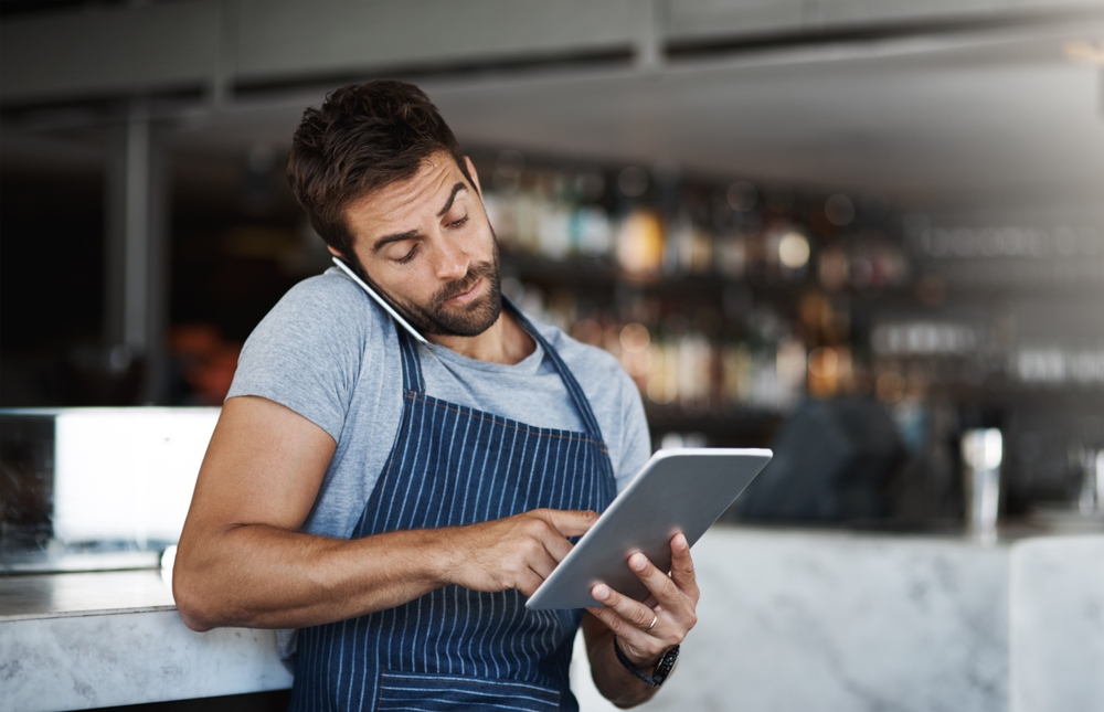 A waiter taking a phone call.