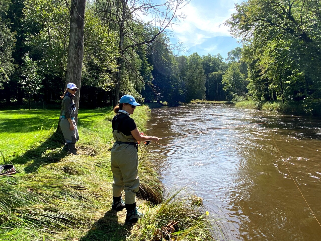 Participants in Casting For Recovery fish along the riverbank