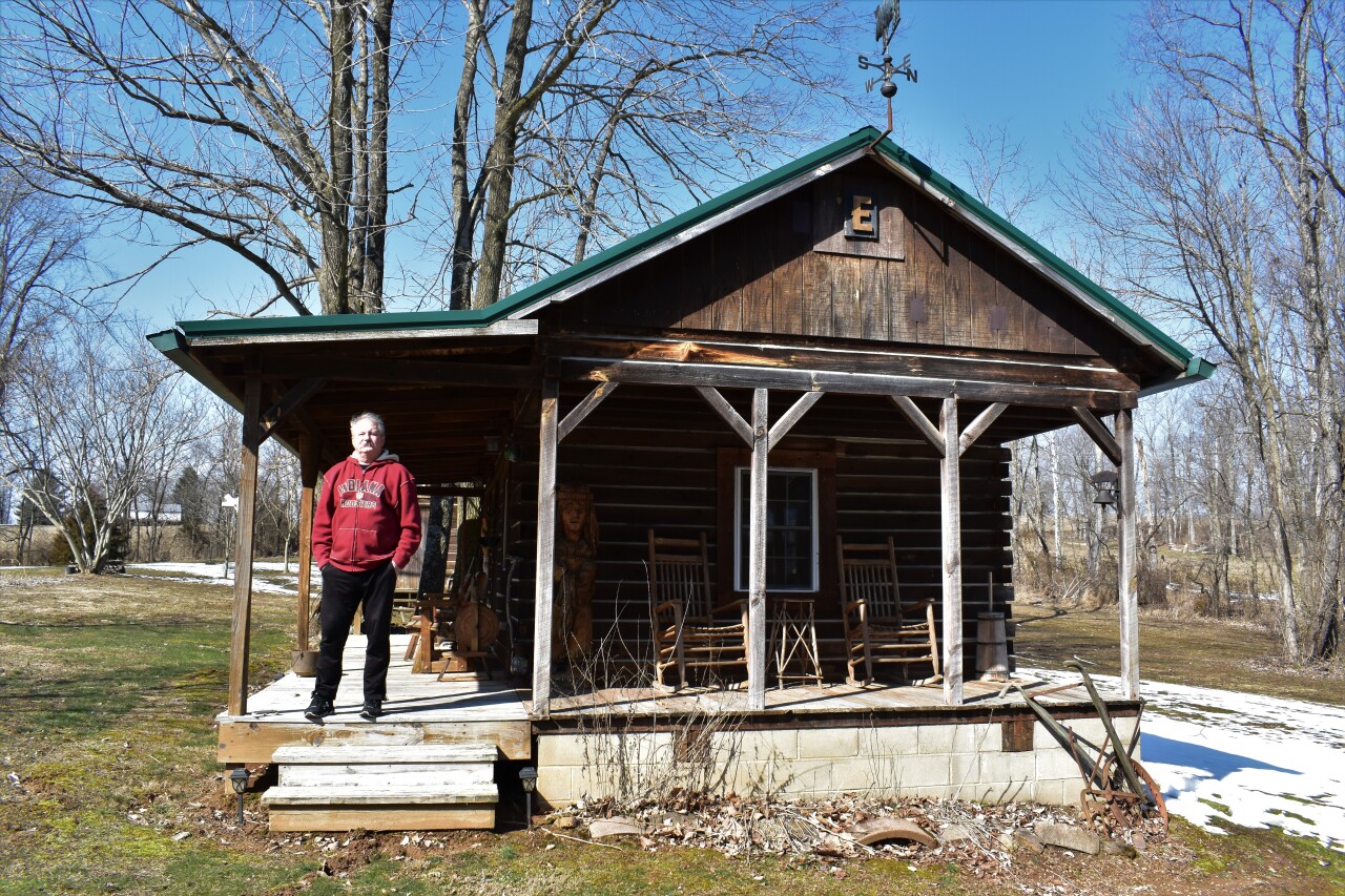 Charles Edwards stands outside a guest cabin located on the 25-acre homestead where he lives in Bedford, Indiana.