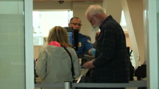 Travelers move through a security line at Denver International Airport.