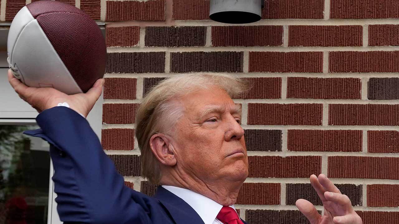 Former President Donald Trump throws a football to the crowd during a visit to the Alpha Gamma Rho, agricultural fraternity, at Iowa State University before an NCAA college football game between Iowa State and Iowa, Saturday, Sept. 9, 2023, in Ames, Iowa.