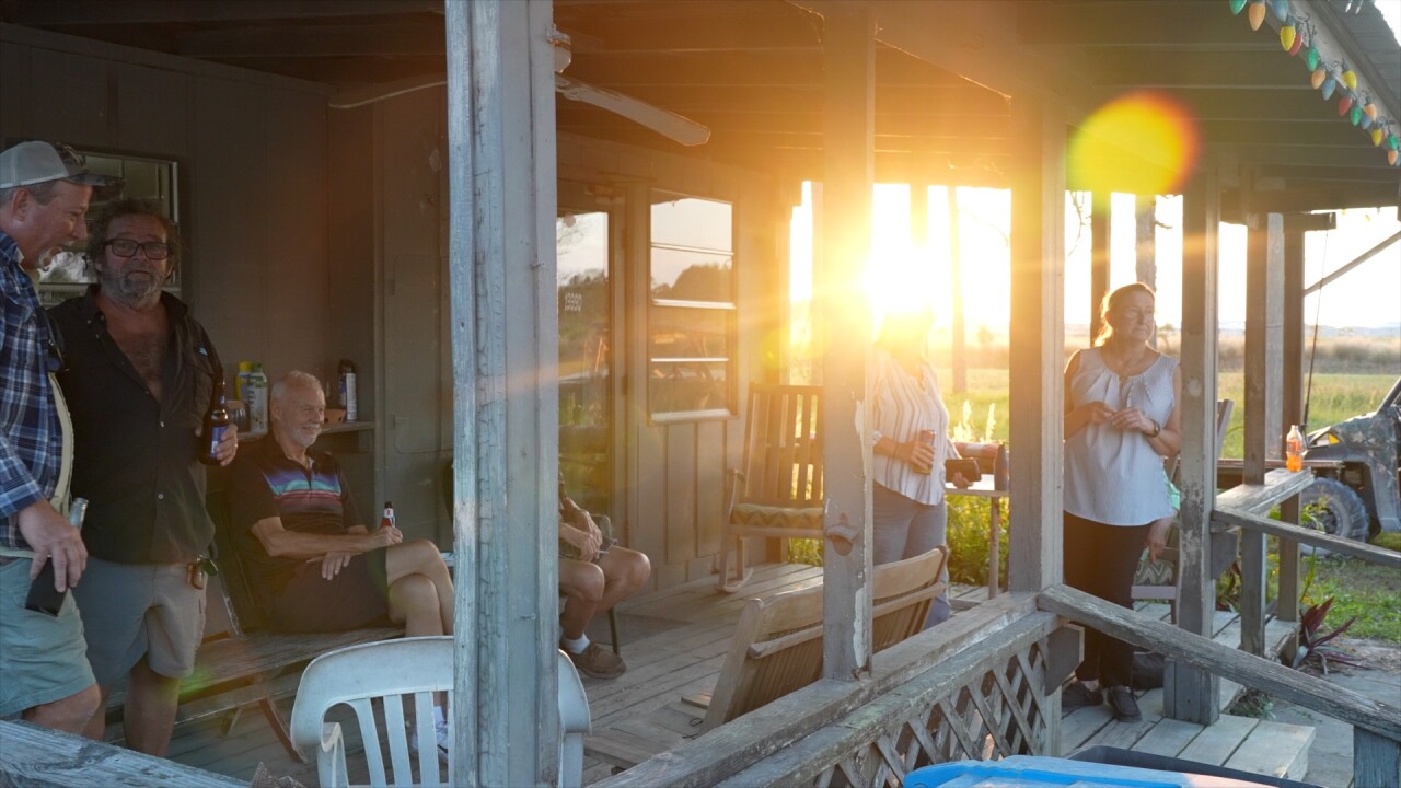 Neighbors sit on the porch of the Corkscrew Country Store. 