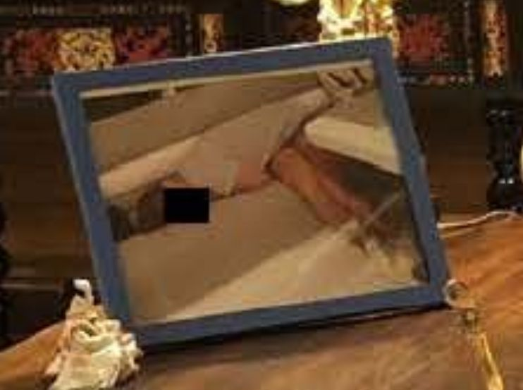 A zoomed-in image of a picture frame on Epstein's desk that appears to show a woman slumped over.