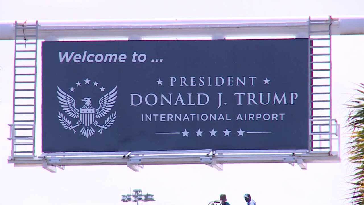 Workers at the airport entrance on July 8, 2026, installed a new sign that says "Welcome to President Donald J. Trump International Airport."