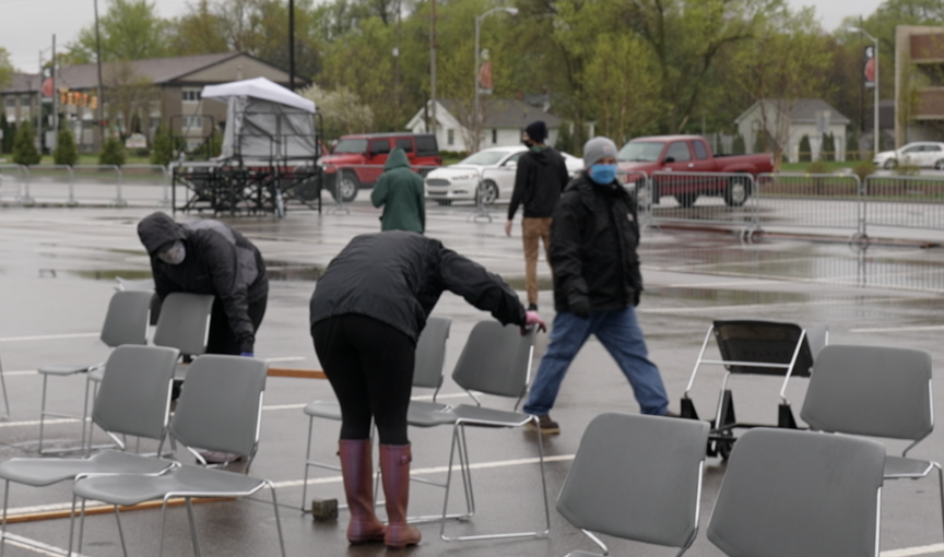 MSU staff measuring distance between chairs for graduation ceremony