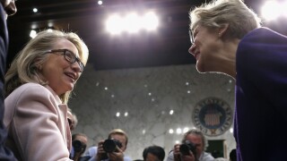 Clinton and Warren shake hands.