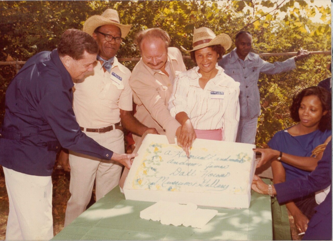Frances Mays cuts a cake at a party to celebrate the designation of the Andrew and James Dall houses as city landmarks in 1982.