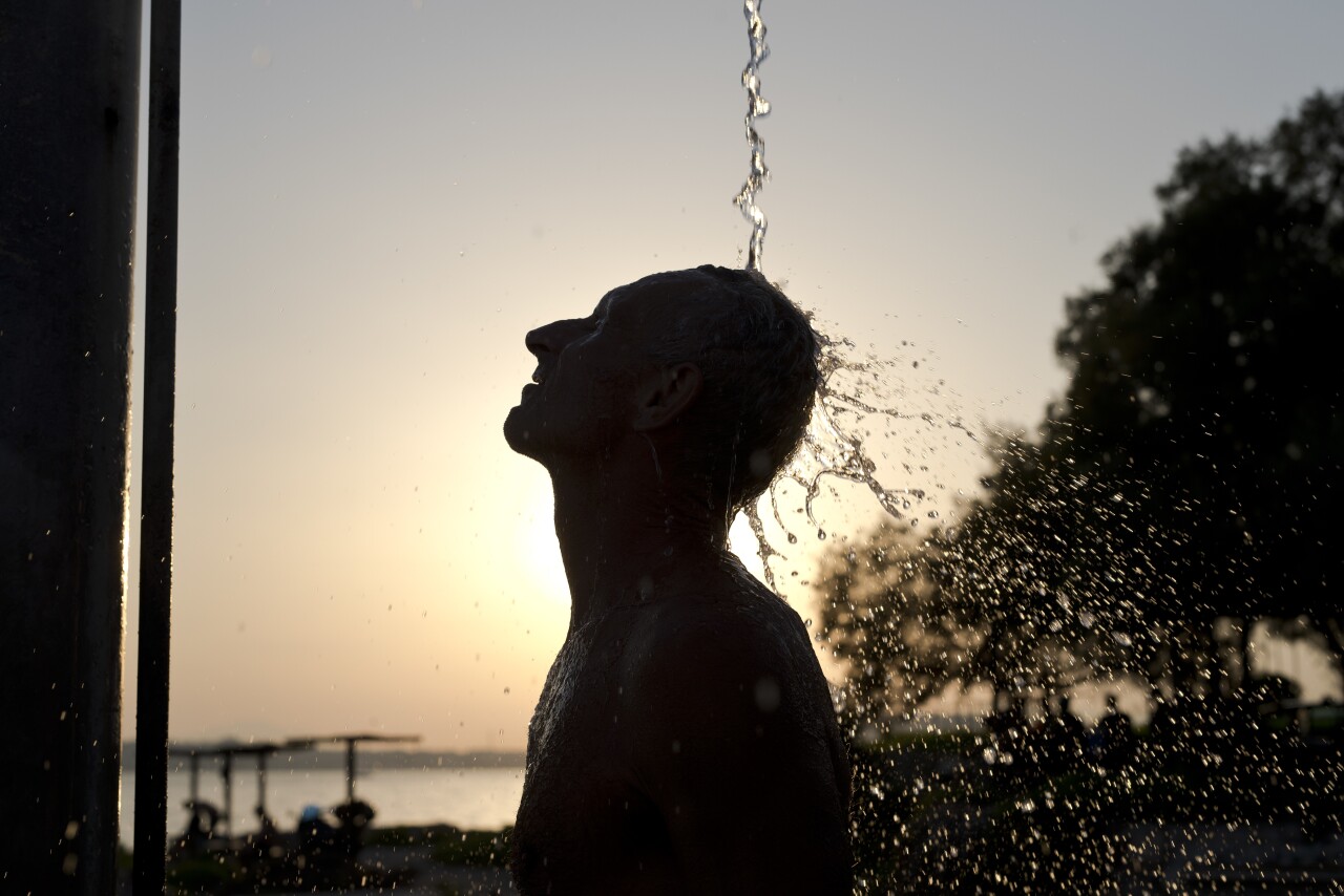 A man takes a shower at a beach of Alimos suburb, in Athens Wednesday, July 12, 2017. A summer heatwave has hit Greece, with temperatures reaching a high of 39 degrees Celsius (102 Fahrenheit) in Athens.(AP Photo/Petros Giannakouris)