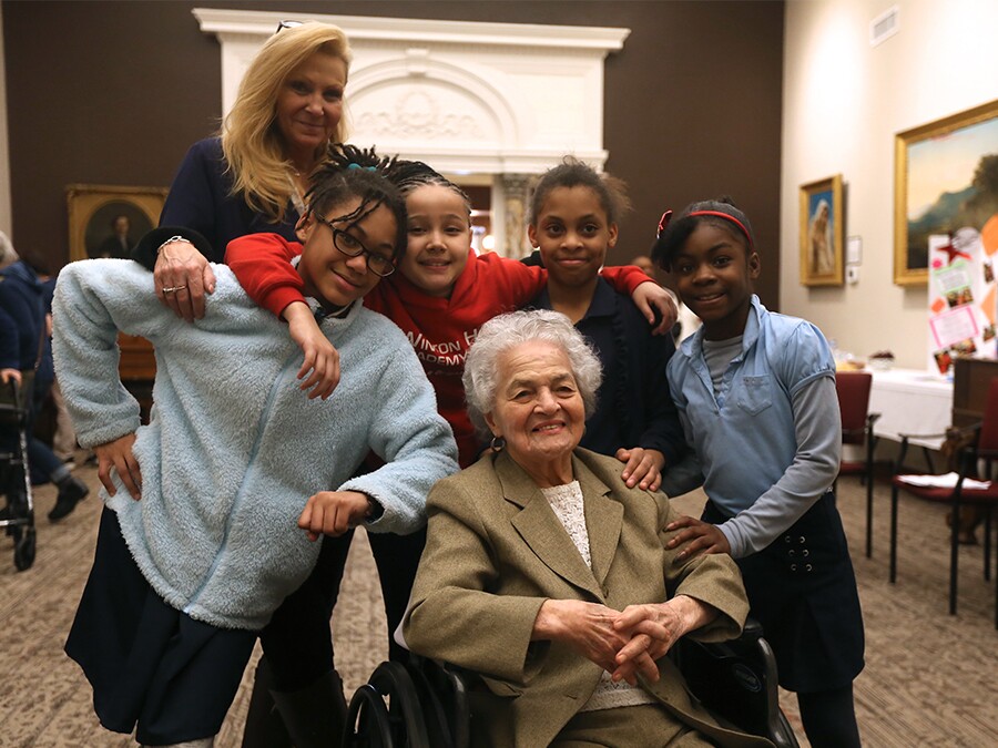 Marian Spencer, seated, in March 2019 with the four Winton Hills Academy students who wrote a book about her. The girls' teacher is pictured, too.