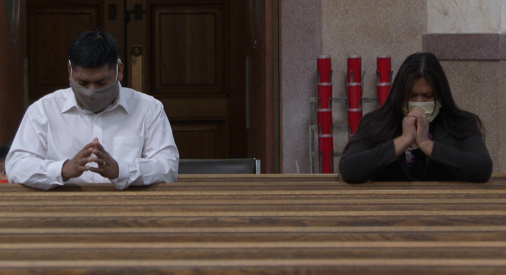 Vidal Ramirez and his wife praying at Holy Family church