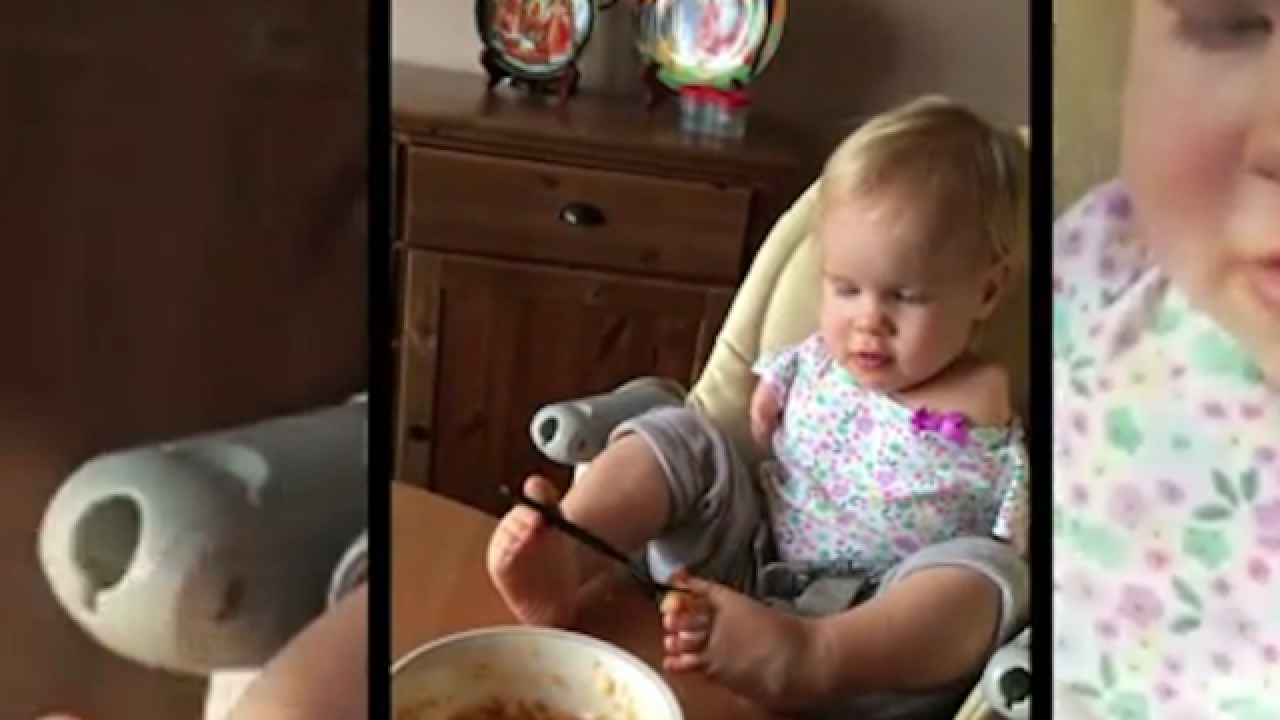 Adorable toddler figures out how to feed herself