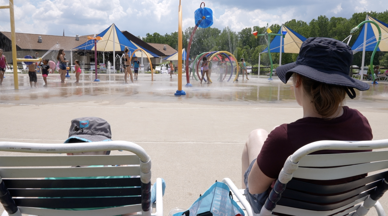 Family sitting down at Splash Pad