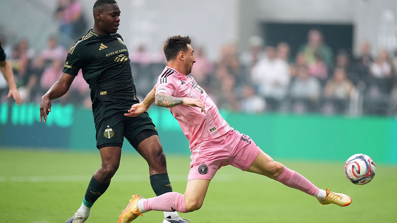 Inter Miami midfielder Leo Messi shoots past Portland Timbers defender Kamal Miller during the first half of an MLS soccer match, Sunday, May 17, 2026, in Miami.