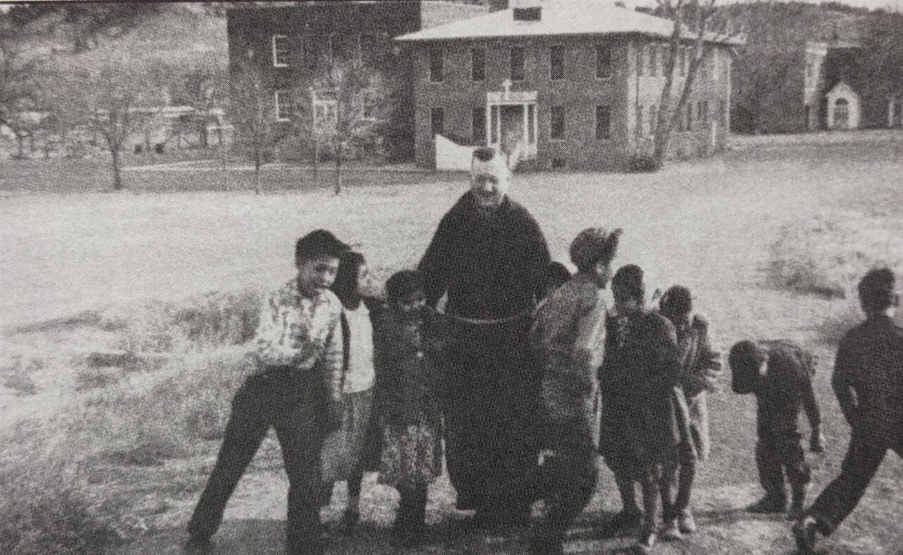 Children walk with Priest at St. Labre campus in Ashland, Montana, 1916