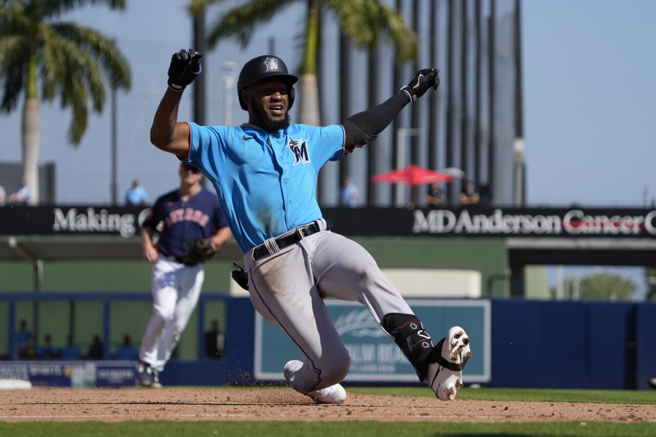 Miami Marlins outfielder Bryan De La Cruz slides into third base during sixth inning of spring training game vs. Houston Astros, Feb. 27, 2023