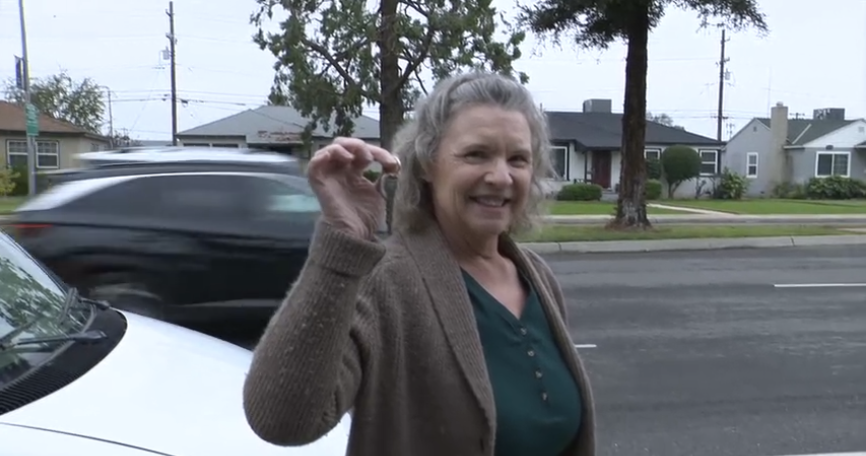 Vicky Thrasher, Executive Director of Critters Without Litters, holds up keys to the Chevy Astrovan donated by the city