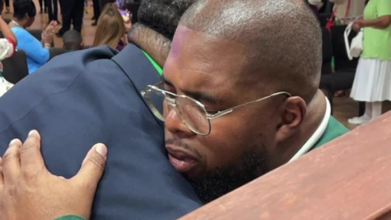 Carlos Edwards (right) embraces his brother Julius during a service for their mother. March 2, 2024