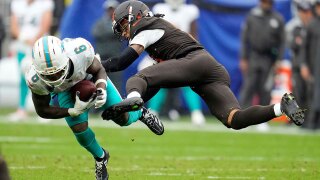 Miami Dolphins wide receiver Malik Washington (6) is hit by Cleveland Browns safety Rayshawn Jenkins in the second half of an NFL football game in Cleveland, Sunday, Oct. 19, 2025. 