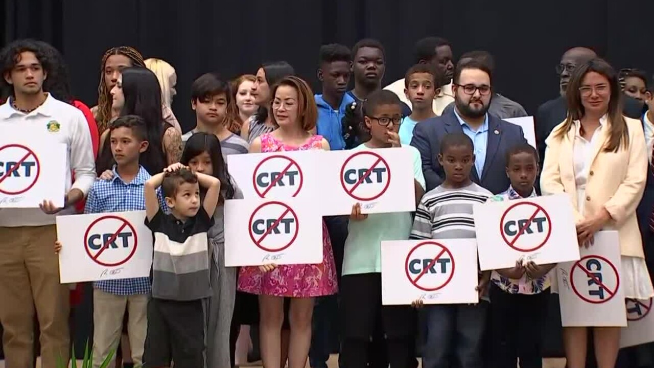 Students hold anti-citical race theory signs at Mater Academy Charter Middle-High School in Hialeah Gardens on April 22, 2022