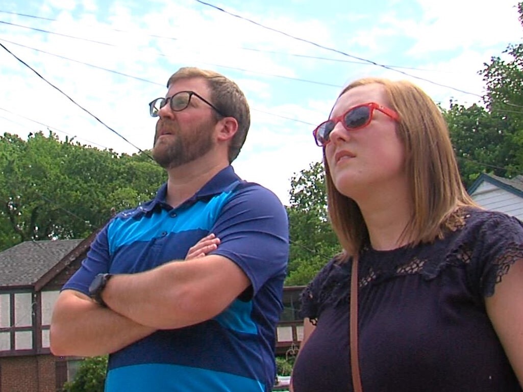 Rich Goodman, left, and his wife, Amy, watch at a Deer Park Roofing crew installs a new roof on May 24, 2021.