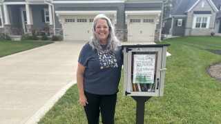 Lana Clark stands next to her free little library in North Ridge Pointe