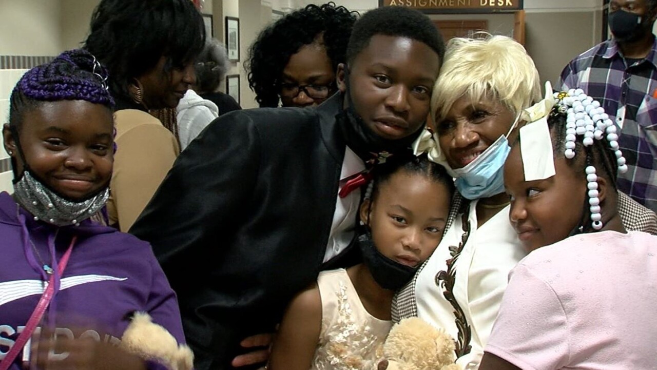 The Thompsons' four adoptive children pose for a picture with Karen Thompson's mom after the proceedings. The children and grandma have their masks pulled down and are all smiling.