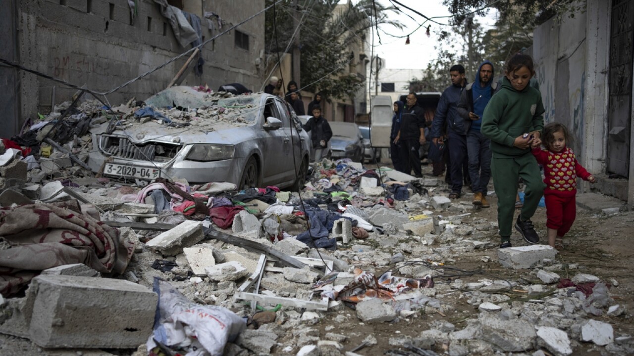 Palestinians look at the destruction after an Israeli airstrike in Rafah, Gaza.