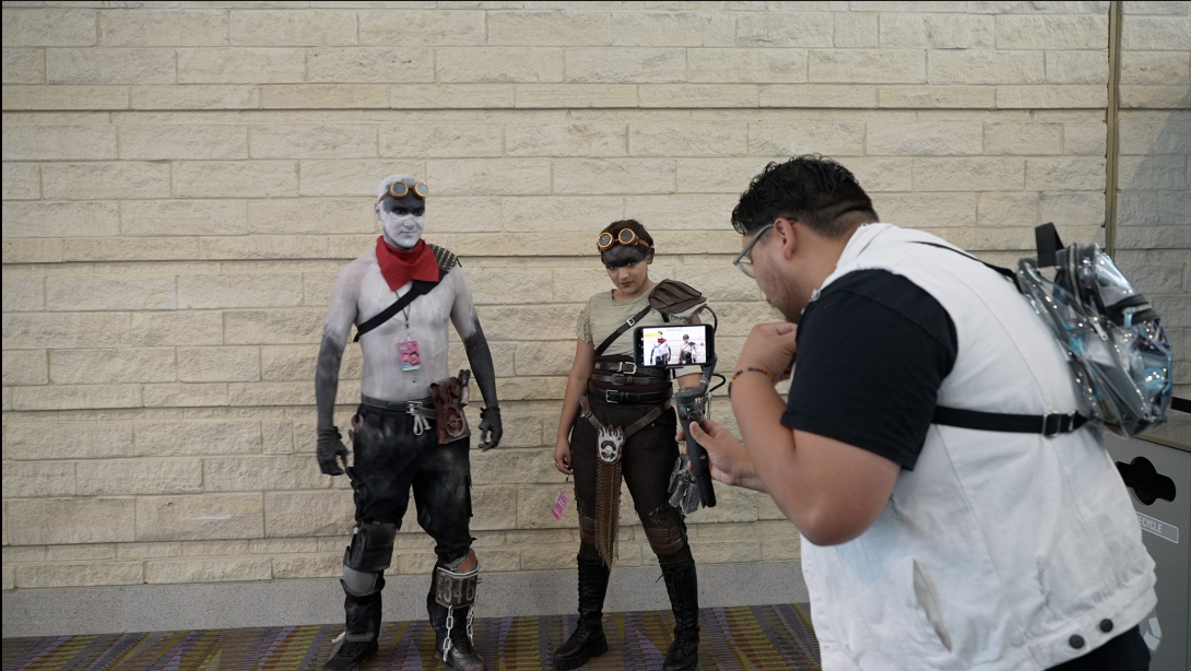 Influencer Franco Hernandez takes a photo of two cosplayers