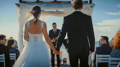 A bride and groom hold hands down the aisle