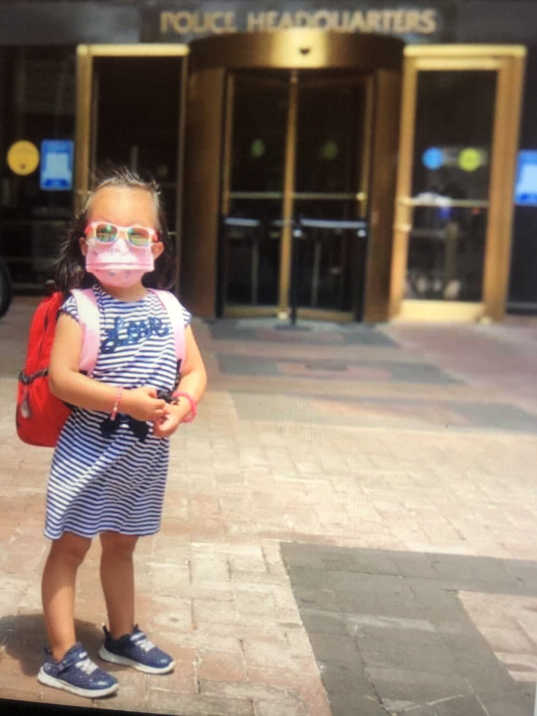Angelina Liu with mask and backpack outside 1 Police Plaza