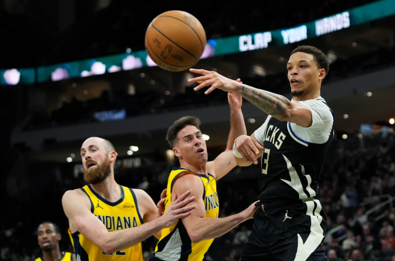 Milwaukee Bucks' Ryan Rollins, right, passes around Indiana Pacers' T.J. McConnell, center, and Jay Huff during the second half of an NBA basketball game, Sunday, March 15, 2026, in Milwaukee.