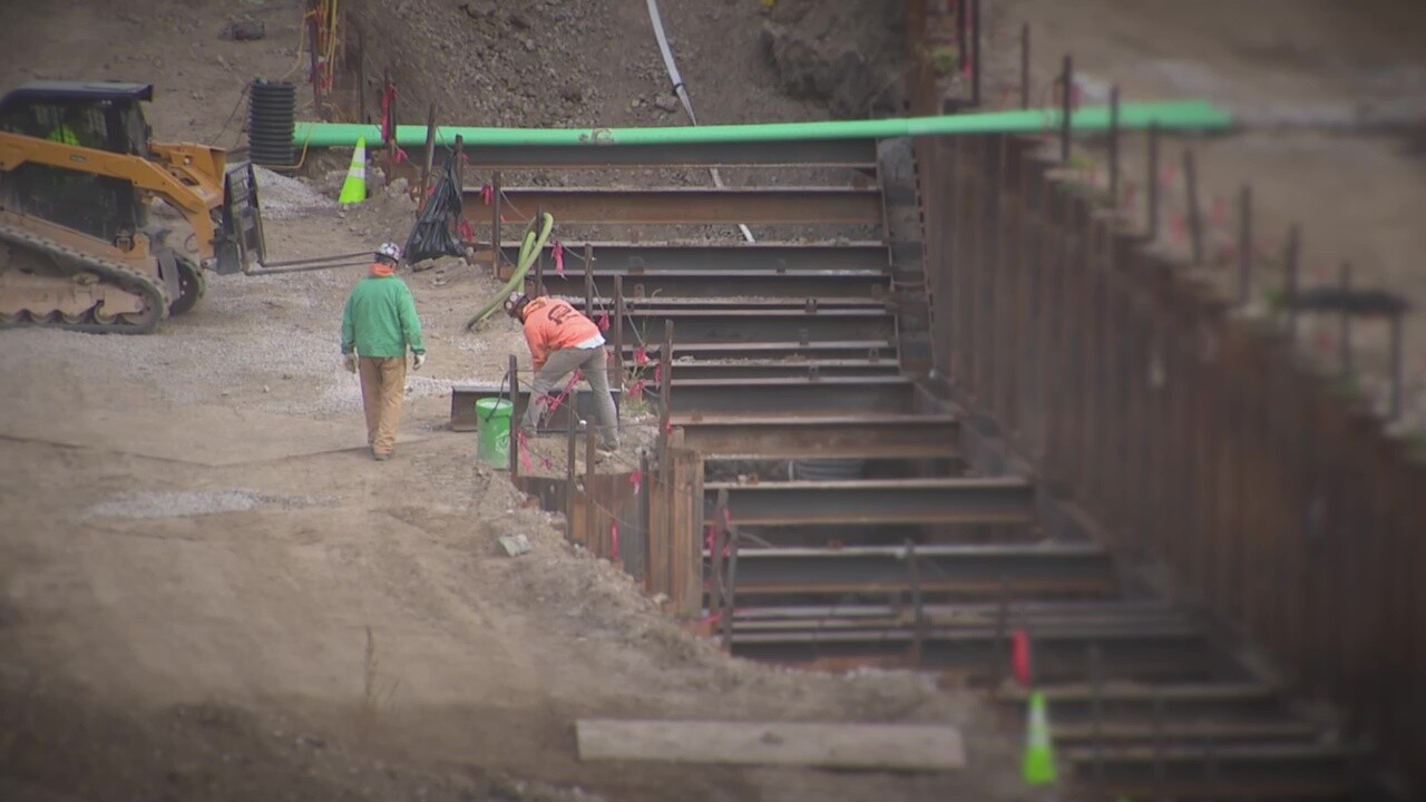 Workers are putting the finishing touches on the Irishtown Bend hillside stabilization project, including repairs to pipes that run beneath the reconfigured slope.