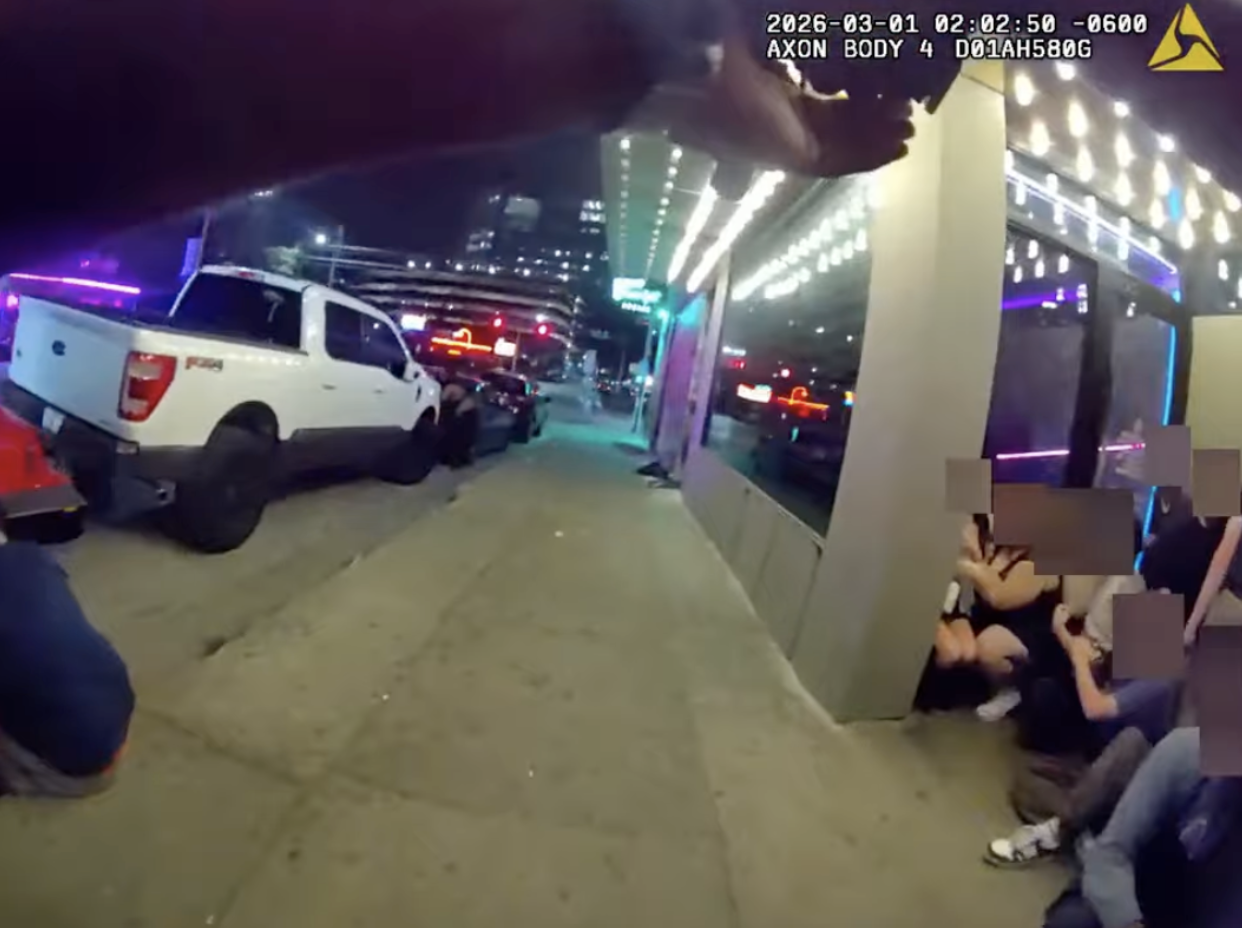 Police body camera video shows an officer looking for the shooter as people hide nearby.