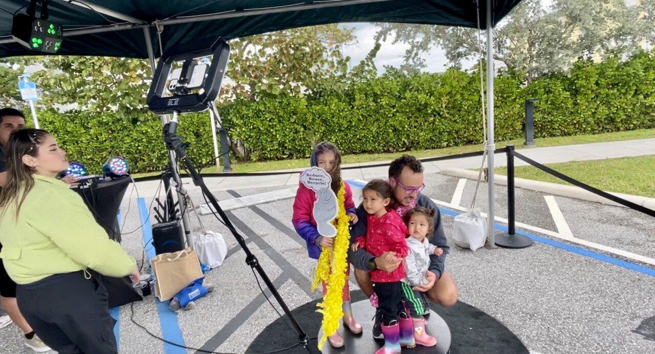 Family takes a 360-degree photo at ManateeFest's Conservation Pledge Station.jpg
