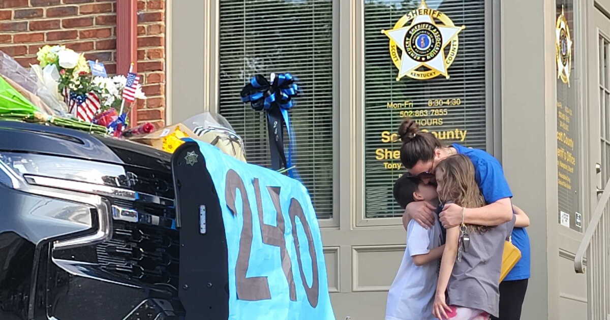 Paying respects to fallen deputy, a mother clutches her kids tight