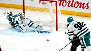 San Jose Sharks goaltender Vitek Vanecek (41) dives as he is scored on by Ottawa Senators' Tim Stutzle, bottom right, after getting caught out of his crease, during the third period of an NHL hockey game in Ottawa, Ontario, on Saturday, March 1, 2025. 