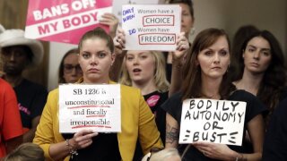 FILE - In this Aug. 12, 2019 file photo, people wait for a Senate hearing to begin to discuss a fetal heartbeat abortion ban, or possibly something more restrictive in Nashville, Tenn. Four years after Tennessee passed a law requiring a 48-hour waiting period for women seeking abortions, a lawsuit challenging the statute’s constitutionality is finally going to trial. Beginning Monday, Sept. 23, attorneys for five of the state’s seven abortion clinics will argue in federal court that the law harms the women it is supposed to help.(AP Photo/Mark Humphrey)
