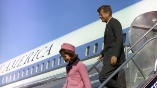 President Kennedy and his wife Jackie walk off a plane in Texas.