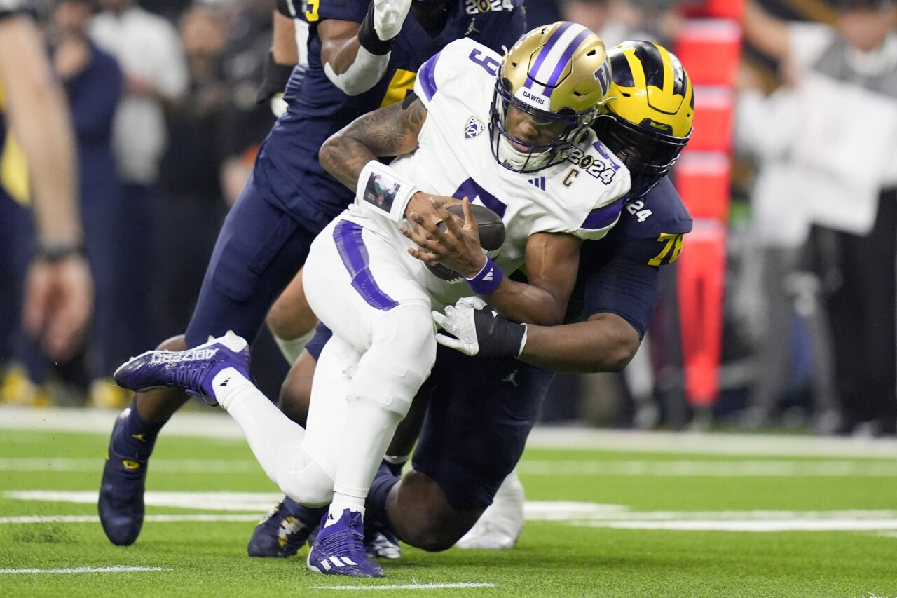 Washington Huskies QB Michael Penix Jr. sacked by Michigan Wolverines defensive lineman Kenneth Grant during first half of College Football Playoff National Championship, Jan. 8, 2024