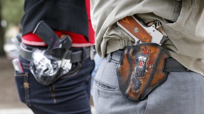 Two people with holstered handguns