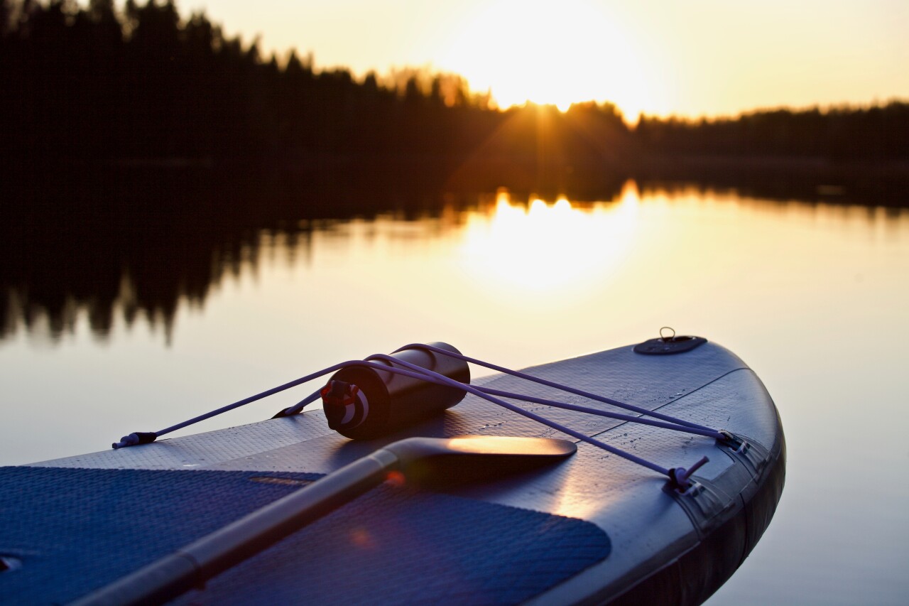 Sup,Board,And,Surf,Board,With,Paddle,On,Blue,Water