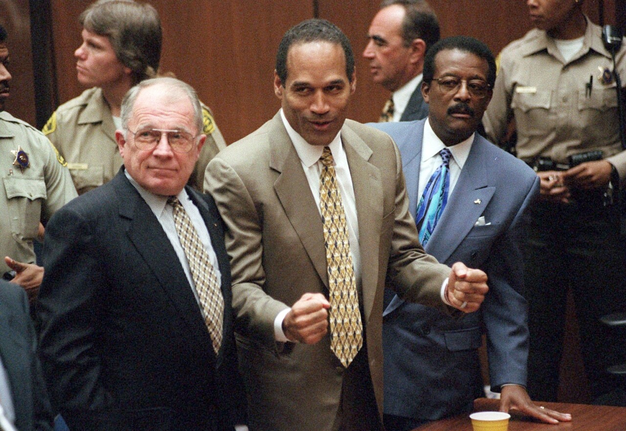 OJ Simpson pumps his fist alongside defense attorneys F. Lee Bailey and Johnnie Cochran after being acquitted in murder trial, Oct. 3, 1995