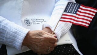 Person holds an American flag at a naturalization ceremony
