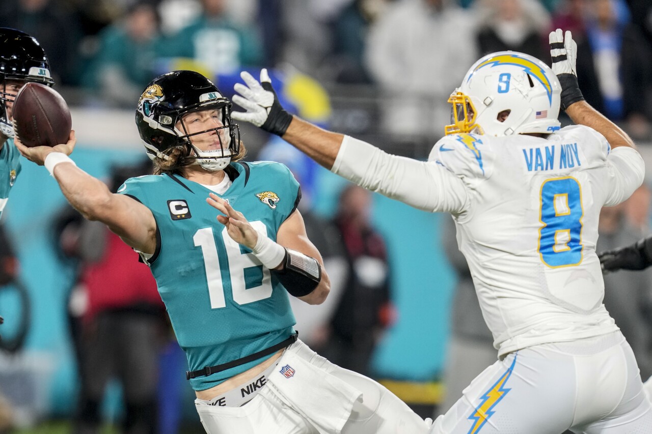 Jacksonville Jaguars QB Trevor Lawrence tries to throw pass under pressure from Los Angeles Chargers linebacker Kyle Van Noy in wild-card playoff game, Jan. 14, 2023