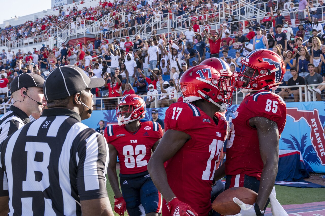 FAU Owls football players celebrate TD while wearing C-USA patches on their jerseys, Sept. 11, 2021