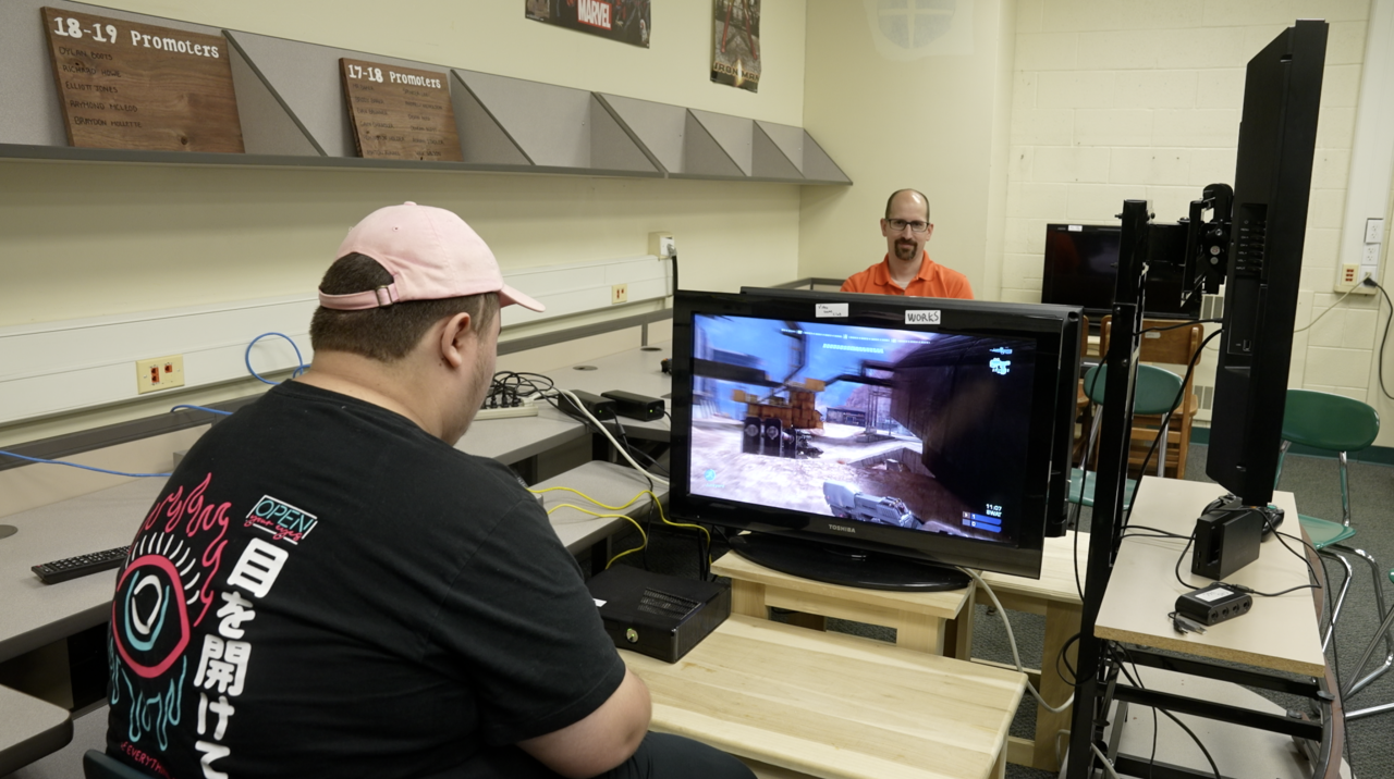 Colin Grey and Mr.Baker are playing videos games.