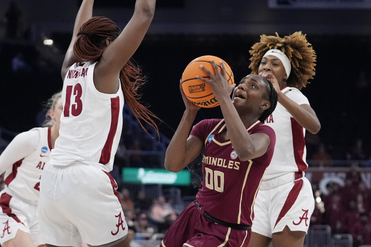 Florida State Seminoles guard Ta'Niya Latson looks to shoot past Alabama Crimson Tide center JeAnna Cunningham in first half of women's NCAA tournament game, March 22, 2024